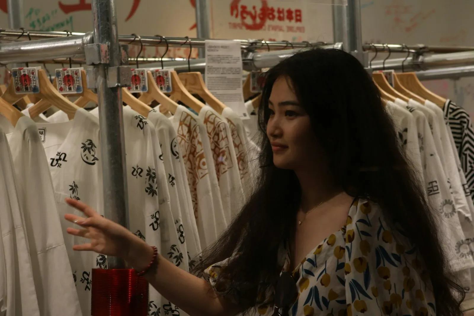Mulher escolhendo roupas em uma arara