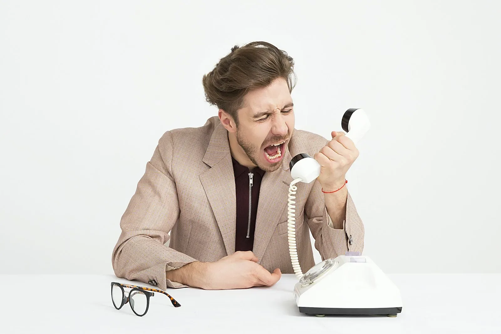 Homem gritando ao telefone em fundo claro